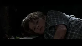 young boy lying on wooden bench in dark room — Batman