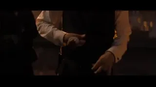 man in vest adjusting tie by city skyline — John Wick: Chapter 4
