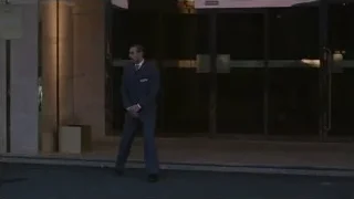 Man in suit walking into hotel — Succession