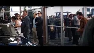 group of people around car in showroom — Ford v Ferrari