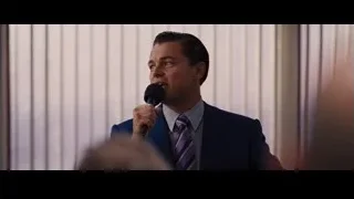 man in suit speaking into microphone in office — The Wolf Of Wall Street