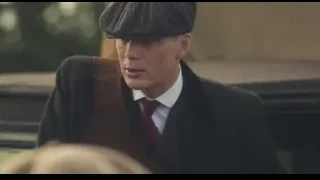 Man in suit and flat cap by stone wall — Peaky Blinders
