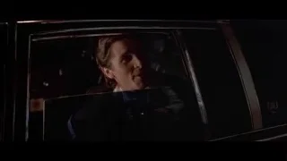 man in dark car looking out window — American Psycho
