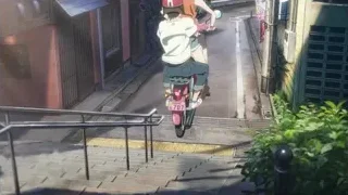 person riding scooter on narrow street — Weathering with You