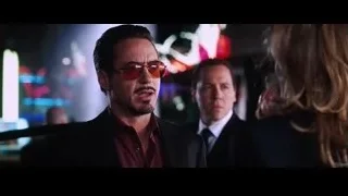 Man in suit and woman in neon lit room — Iron Man