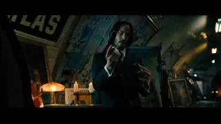 man holding gun in dark room with graffiti — John Wick: Chapter 4