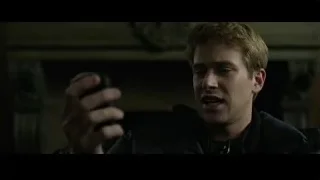 Young man holding remote in dimly lit room — The Social Network