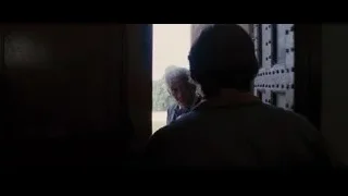 man in suit standing by wooden staircase — Batman: The Dark Knight Rises