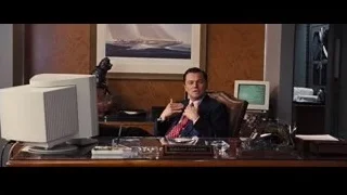 Man in suit conversing at office desk — The Wolf Of Wall Street