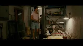 Young man standing in cluttered dim room — The Dictator