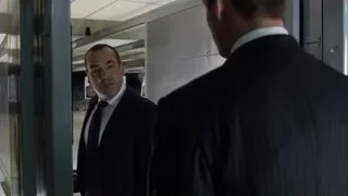 two men in suits standing by glass door — Suits