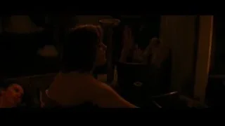 Man lying, woman standing in dimly lit room — Batman: The Dark Knight Rises