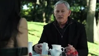 man and woman at garden table with teapot — Suits