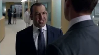 Two men in suits conversing in hallway — Suits