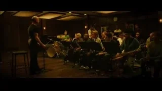 Man leading musicians in dimly lit room — Whiplash