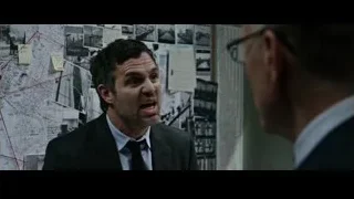Two men talking by wall with photographs — Now You See Me 2