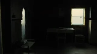 man sitting on couch in dimly lit room — Blade Runner 2049