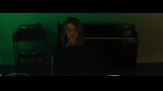 woman sitting at a piano in a dim room — La La Land