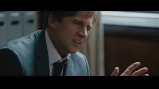 man in suit gesturing at desk in office — The Big Short