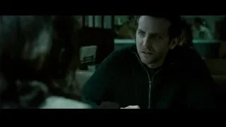 Man and woman sitting in dimly lit room — Limitless