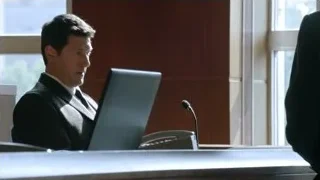 Man in suit at courtroom desk with laptop — Suits