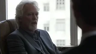 older man in thought by window with city view — Suits