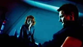 woman standing over unconscious man in dark room — The Avengers