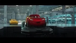 Red car on platform in large room — Cars 3