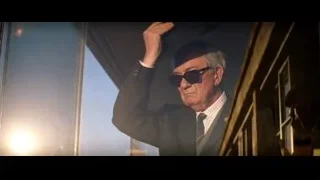 elderly man in suit adjusting hat on train — Ford v Ferrari