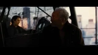 Man sitting in helicopter cockpit with cityscape view — Batman: The Dark Knight Rises