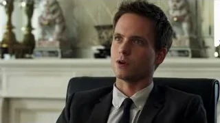 Young man in suit sitting in office chair — Suits