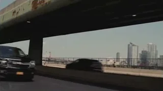 Black SUV driving with city skyline — Succession