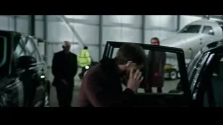 man on phone in hangar with black car — Now You See Me 2