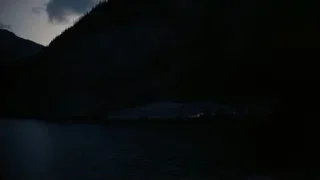 night mountain range with boat on water — Interstellar