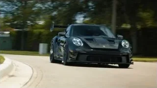 black Porsche race car driving on winding road — Sports Cars