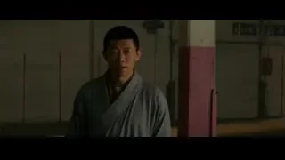 man in martial arts stance in dimly lit room — Bruce Lee: Birth of The Dragon