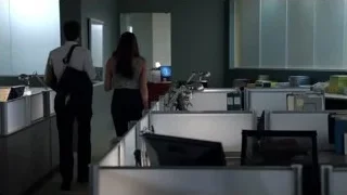 Man and woman walking through office cubicle — Suits
