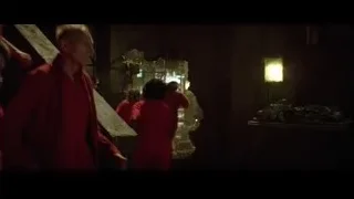 People in red robes walking in dark hallway — Batman