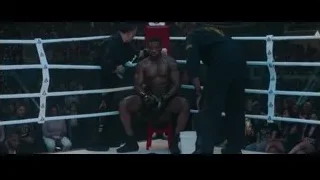 man sitting on stool in boxing ring — Creed 3