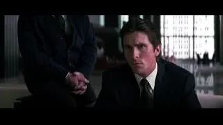 man in suit sitting on couch in city view — Batman: The Dark Knight