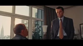Man in suit standing by window, facing another — The Wolf Of Wall Street