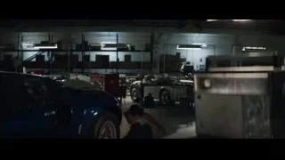 man working on blue sports car in garage — Ford v Ferrari