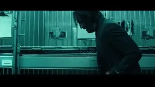 man in suit in front of metal cages — John Wick