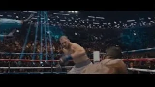 Man in striped jacket in front of crowd — Creed 2