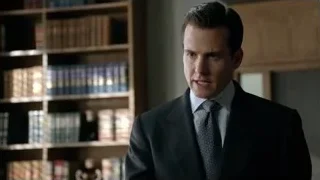 Man in suit standing by bookshelf — Suits