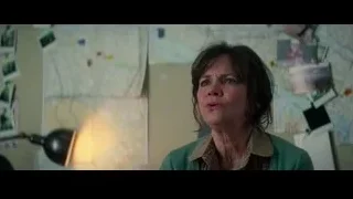 woman with serious expression in room with photos — The Amazing Spider Man 2