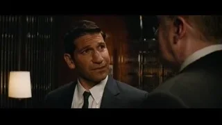 Two men in suits in dimly lit room — Ford v Ferrari