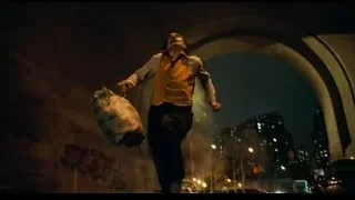 man in yellow vest in stone alleyway at night — Joker