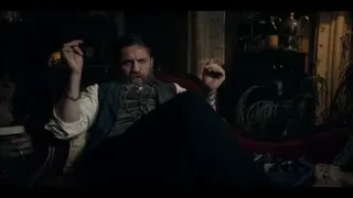 Man with beard in red armchair, hands raised — Peaky Blinders