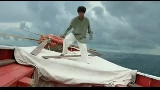 Man standing on boat holding paddles — Life of Pi